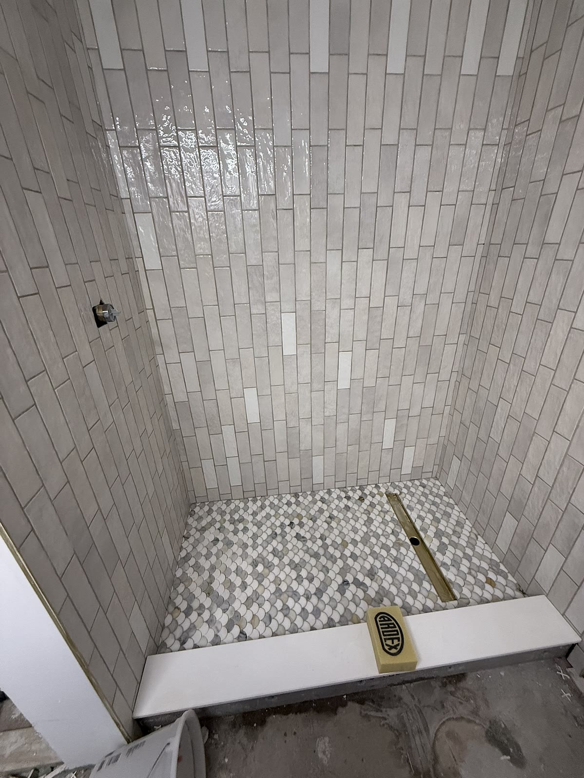Custom tile shower in progress with fish-scale mosaic floor, Yardley